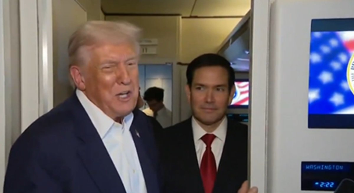 Donald Trump speaks while Marco Rubio stands nearby on an airplane, with an American flag visible in the background.