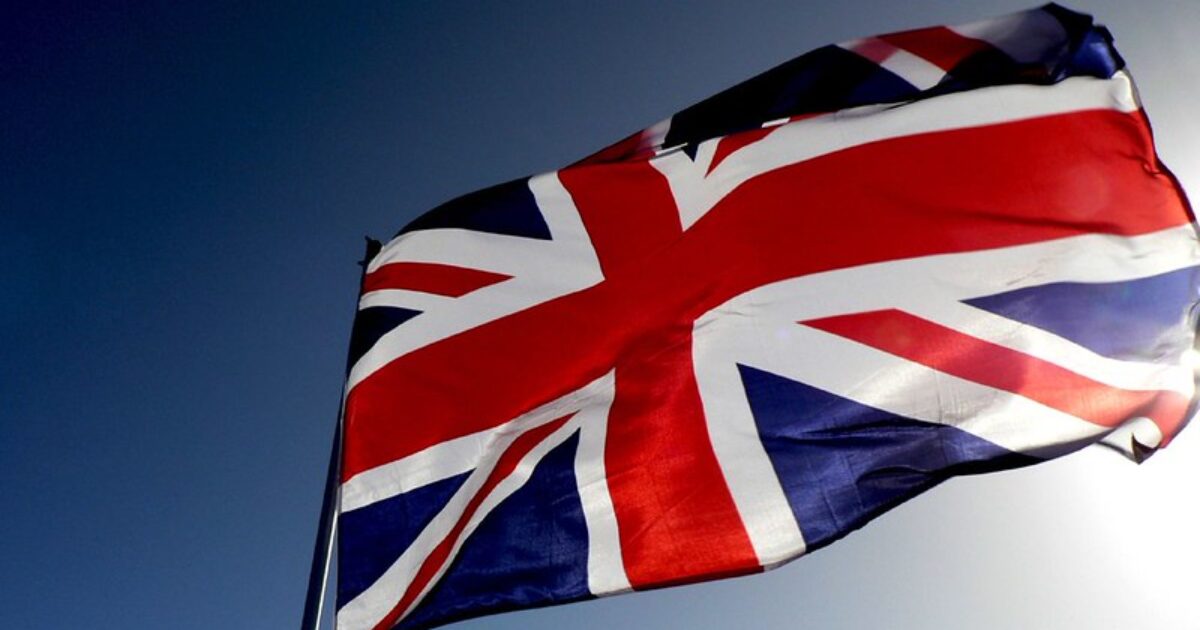 British flag waving against a clear blue sky, symbolizing the United Kingdom's national identity and heritage.