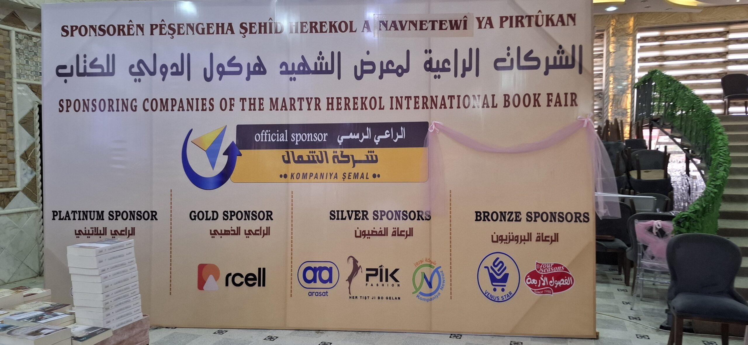 Banner displaying sponsorship categories for the Martyr Herekol International Book Fair, including Platinum, Gold, Silver, and Bronze sponsors.