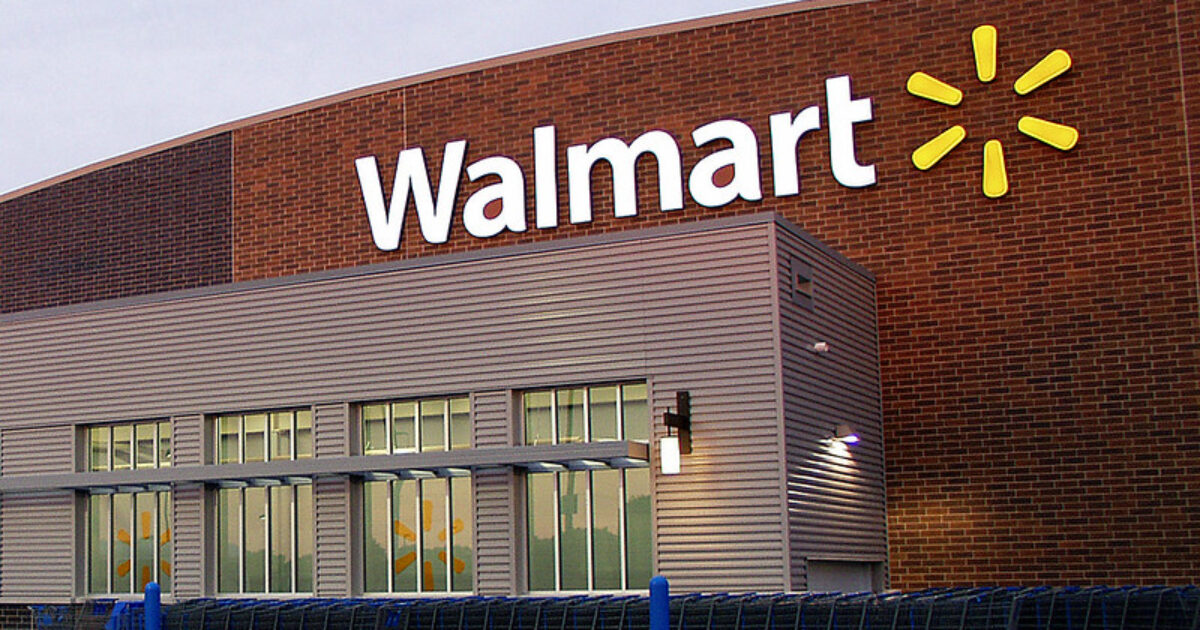 Exterior view of a Walmart store featuring the iconic logo and shopping carts lined up outside.