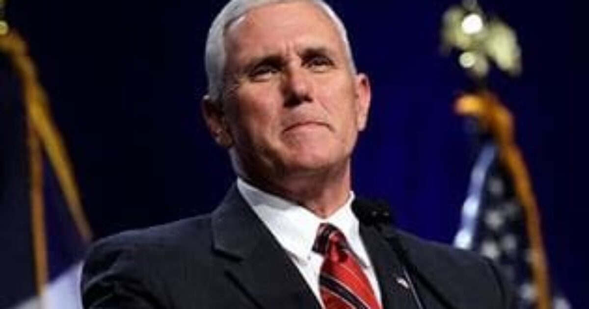 Mike Pence speaking at a podium with flags in the background, conveying a confident and determined expression.