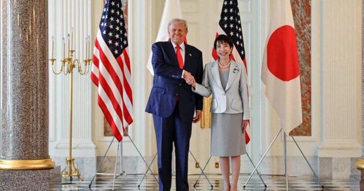 U.S. President Donald Trump and Japanese official shake hands in front of American and Japanese flags, symbolizing diplomatic relations.