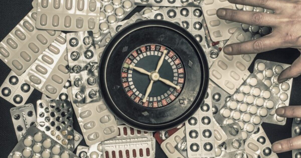 A roulette wheel surrounded by various blister packs of medication, symbolizing the gamble of health and addiction.