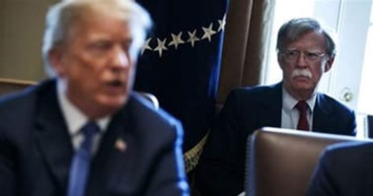 Donald Trump speaks during a meeting while John Bolton listens intently in the background, highlighting key moments in political discussions.