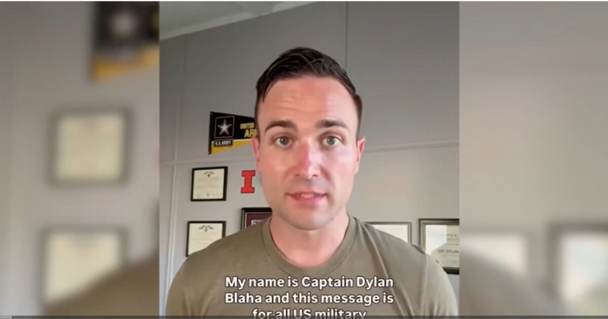 Captain Dylan Blaha addresses U.S. military personnel, sharing an important message in a professional setting with military awards displayed in the background.