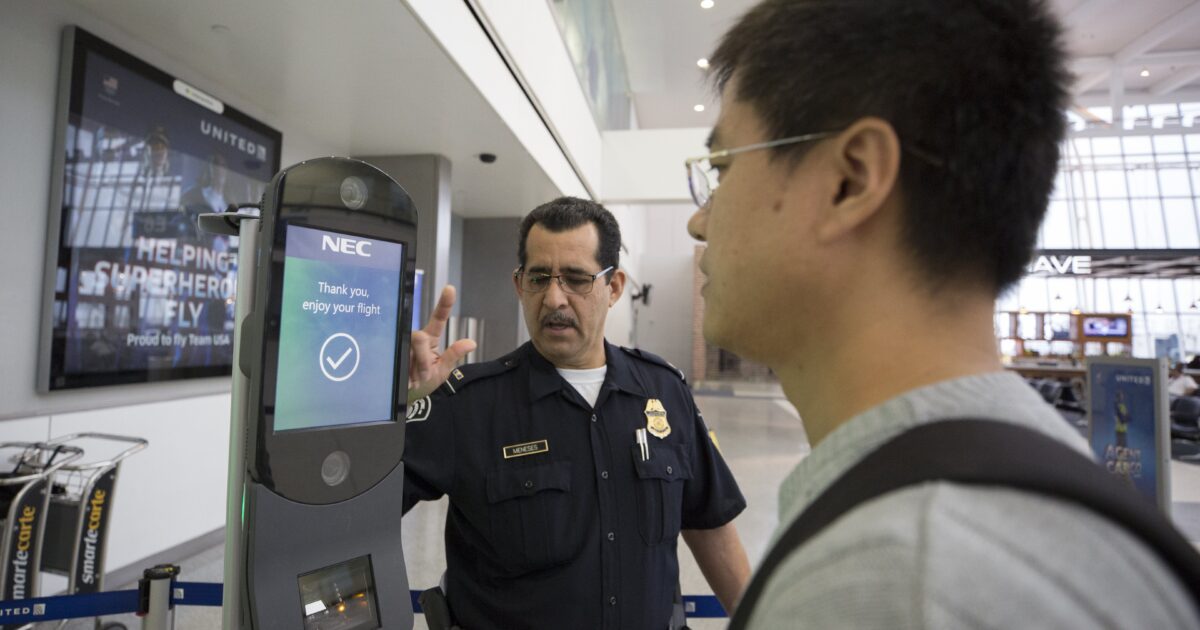 Airport security officer assisting a traveler at a self-service kiosk displaying a flight confirmation message.