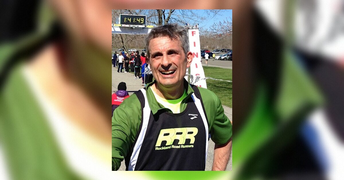 Runner celebrating a finish at a race with a time of 1:41:49, wearing a green Rockland Road Runners jersey in a park setting.