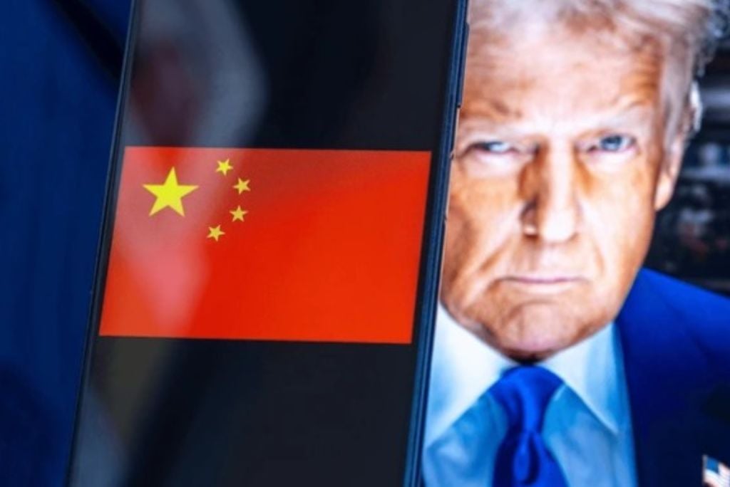A smartphone displaying the Chinese flag alongside a close-up image of a man with blonde hair and a blue suit, symbolizing political themes.