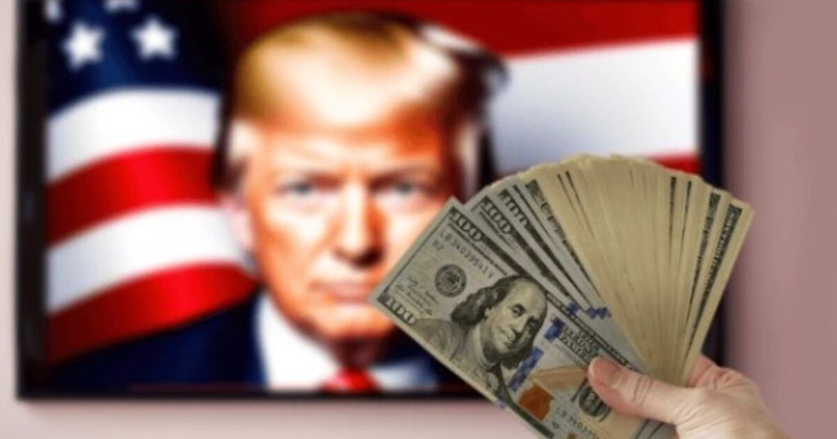 Hand holding cash in front of a television displaying an image of a person with an American flag background.