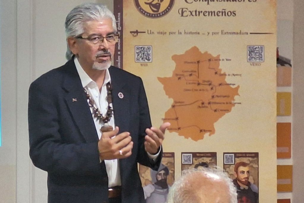 Speaker presenting historical information about Extremadura, with a map and visuals in the background.