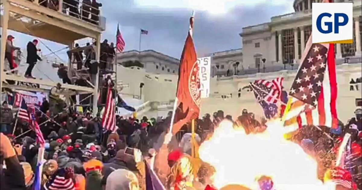 Crowd of protesters at the U.S. Capitol during a rally, waving flags and gathering near a fire, highlighting a significant moment in recent political history.