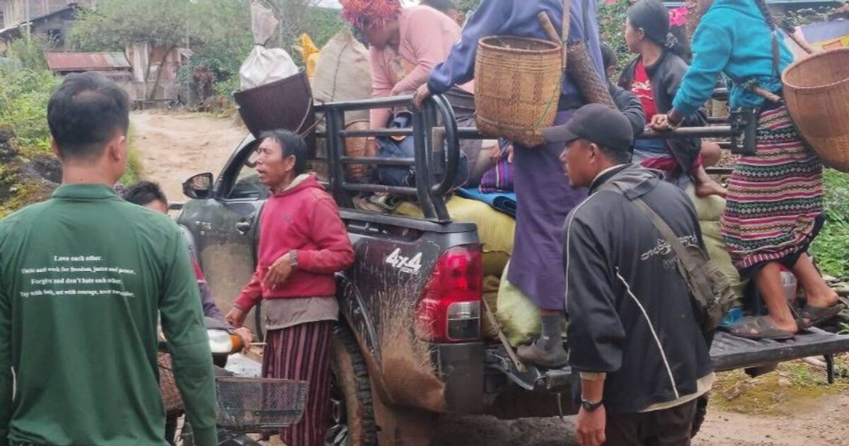 Local villagers loading goods onto a pickup truck in a rural area, showcasing community engagement and traditional practices.