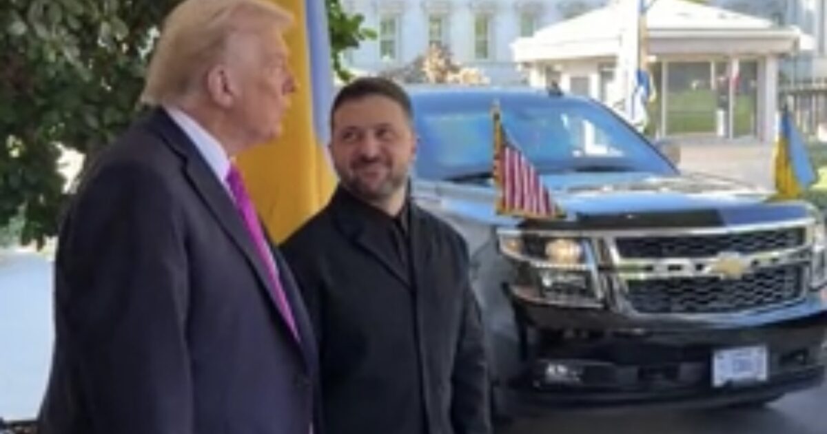 Former President Donald Trump and Ukrainian President Volodymyr Zelensky engage in conversation outside a vehicle adorned with flags.