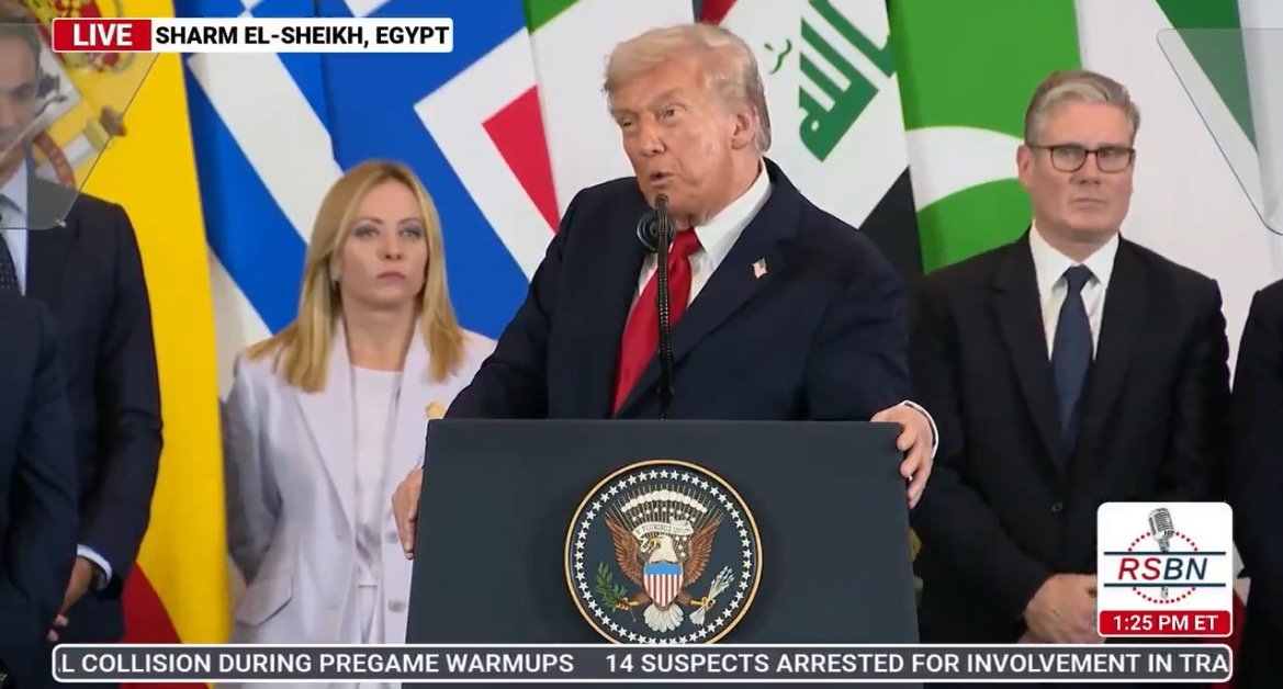 Former President Donald Trump speaks at a podium during an event in Sharm El-Sheikh, Egypt, surrounded by international leaders and flags.
