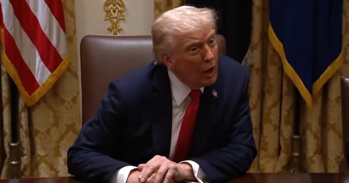 Donald Trump speaking during a meeting in the Oval Office, with American flags and drapery in the background.