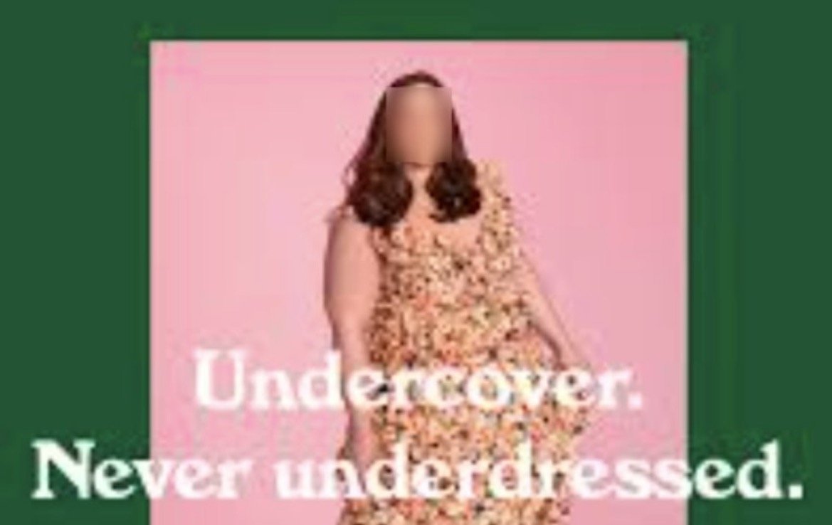 Model wearing a floral dress against a pink background, promoting stylish and confident fashion choices.