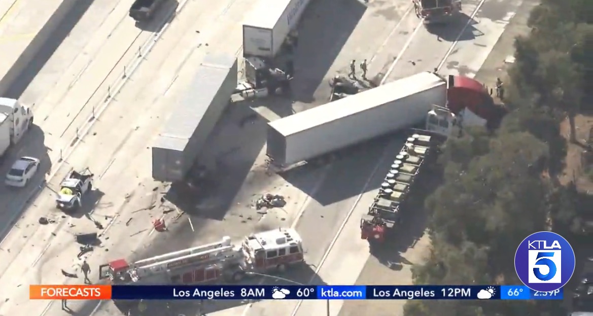 Aerial view of a multi-vehicle accident on a highway, featuring overturned trucks, debris, and emergency responders at the scene.