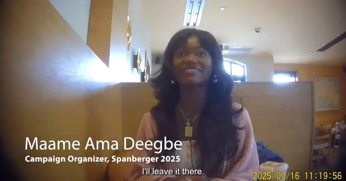 Maame Ama Deegbe, a campaign organizer for Spanberger 2025, smiles while speaking in a cafe setting.