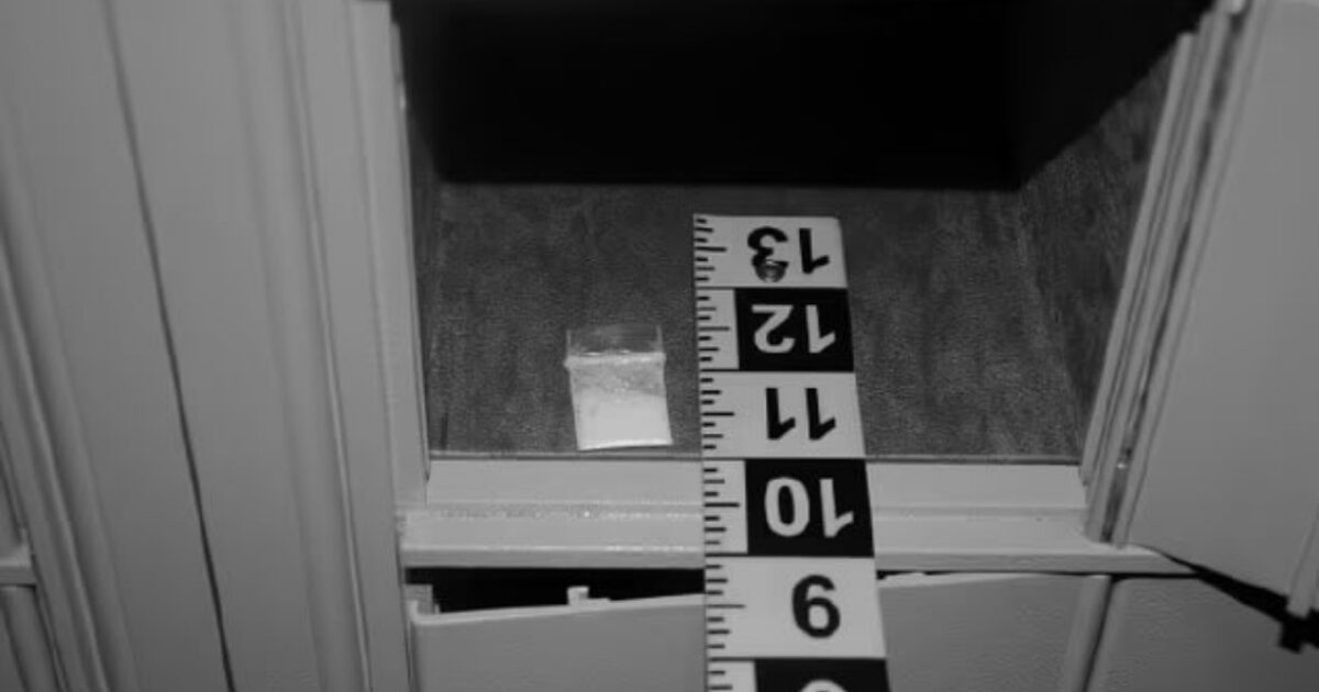 Evidence bag containing a white substance inside a mailbox, with a measuring tape for scale.