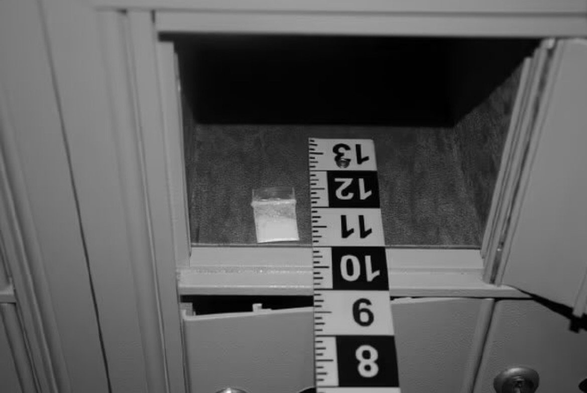 Evidence bag containing a white substance inside a mailbox, with a measuring tape for scale.
