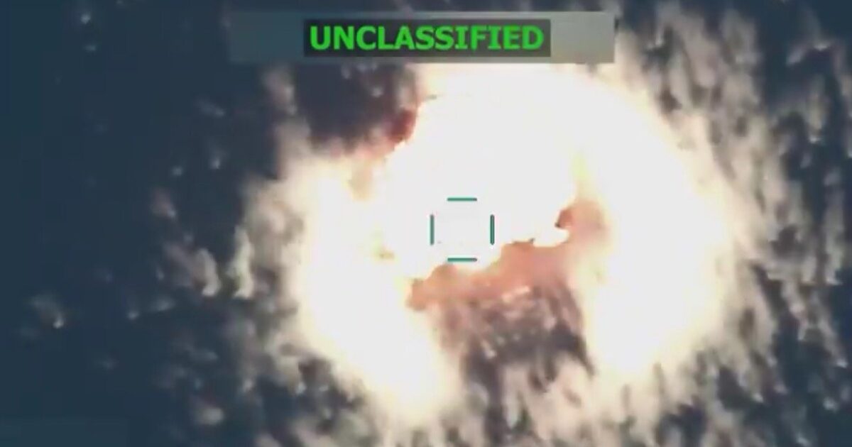 Aerial view of an explosion captured in an unclassified military video, showcasing a bright fireball against a dark background.