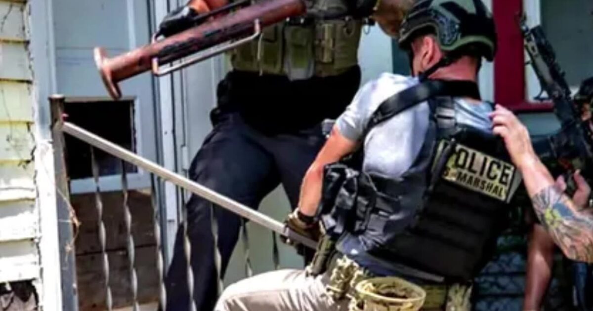 U.S. Marshals conduct an operation, showcasing tactical teamwork and law enforcement efforts during a significant police action.