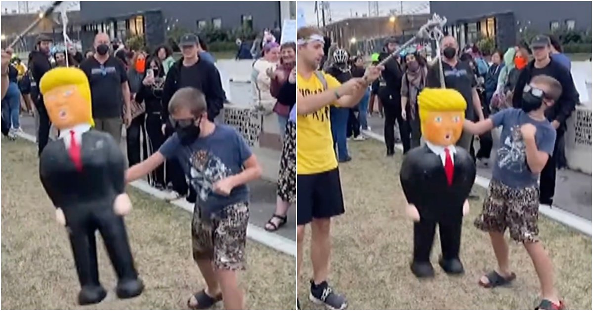 Children participate in a lively outdoor event, hitting a piñata resembling a political figure while onlookers cheer, showcasing a spirited atmosphere.