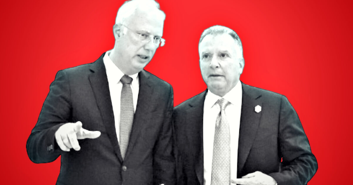 Two business professionals engaged in conversation against a vibrant red background, discussing important topics in a formal setting.