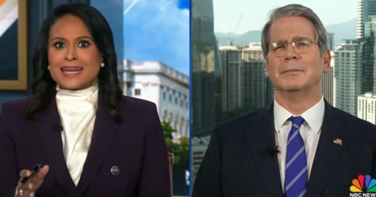 News anchors discussing current events with a city skyline backdrop, highlighting a live broadcast segment.