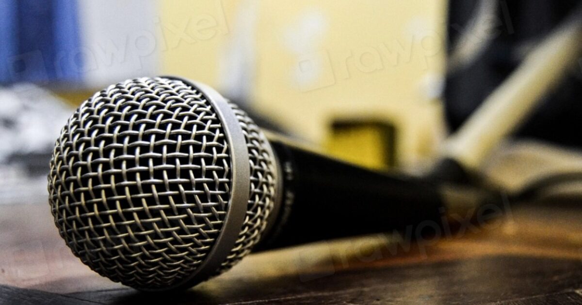 Close-up of a microphone resting on a wooden surface, ideal for music performances or recording sessions in a home studio setting.