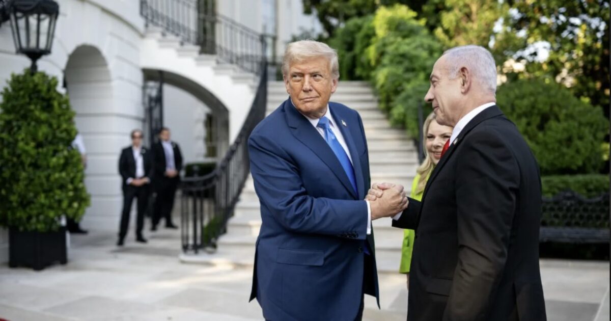 Donald Trump and Benjamin Netanyahu shake hands outside the White House, surrounded by greenery and security personnel, during a diplomatic meeting.