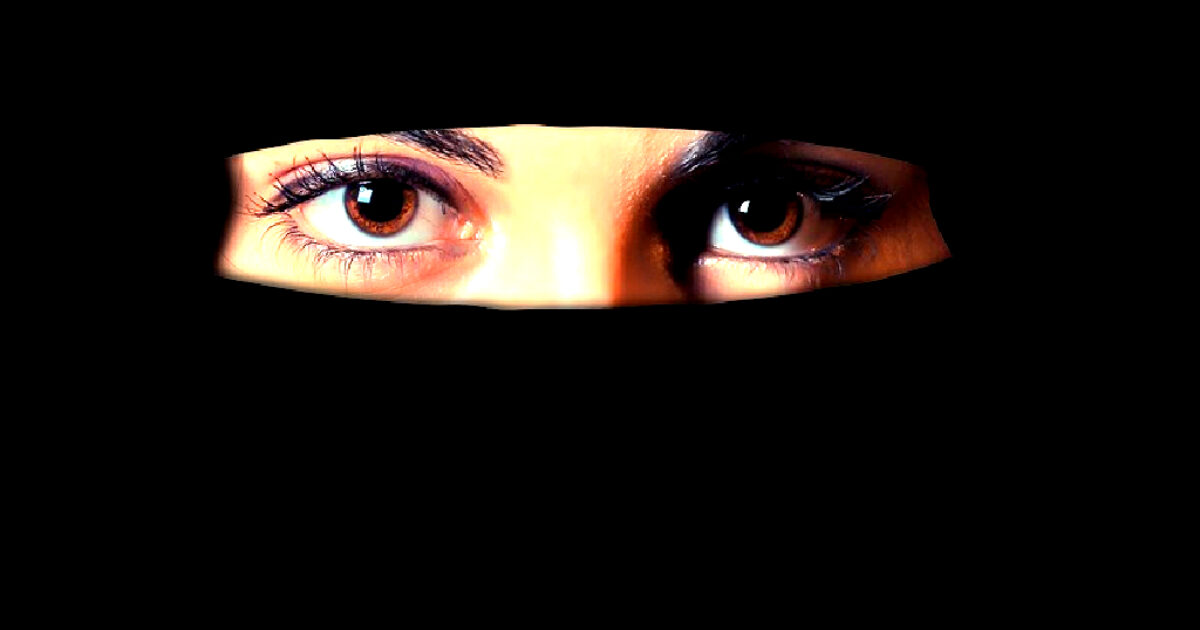 Close-up of a woman's eyes peering from behind a black veil, showcasing detailed eyelashes and a captivating gaze.