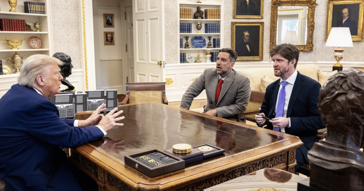 Donald Trump engages in a discussion with two men at the Resolute Desk in the Oval Office, surrounded by historical portraits and office decor.