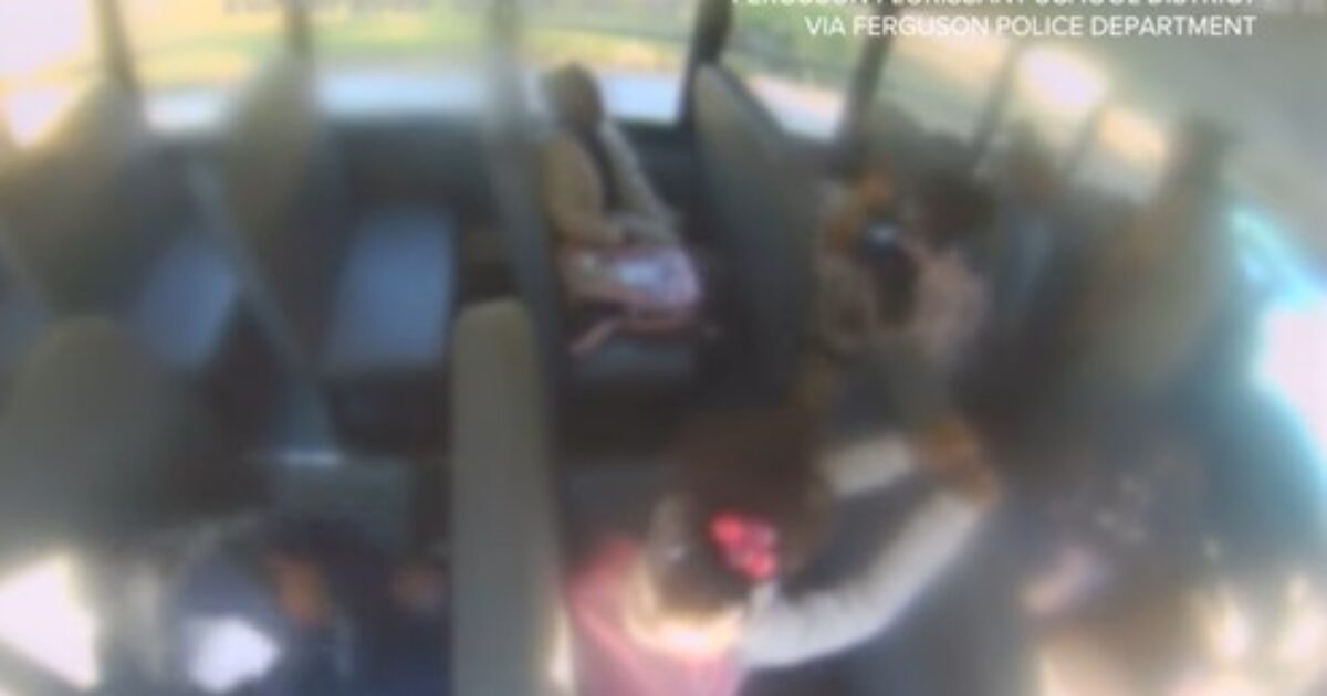 School bus interior showing students and a driver, captured from a surveillance camera, highlighting the daily environment of school transportation.