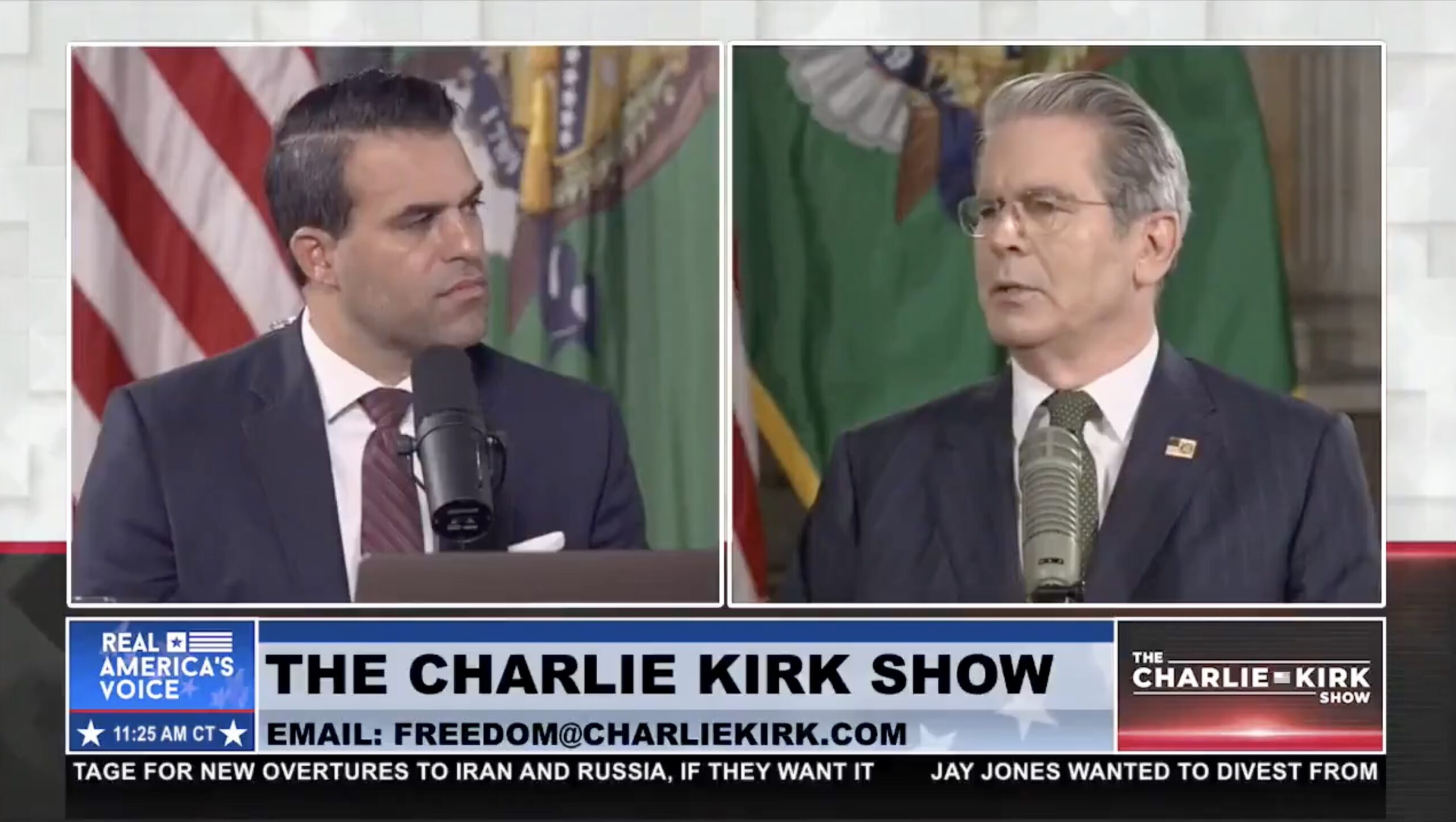 Two men engage in discussion on The Charlie Kirk Show, featuring a backdrop of flags and a microphone setup.