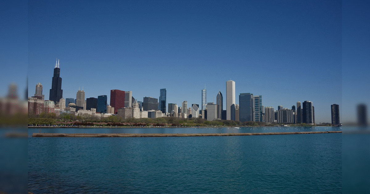 Chicago skyline with skyscrapers alongside Lake Michigan under a clear blue sky.