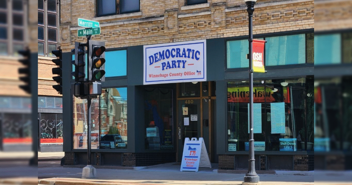 Exterior of the Winnebago County Democratic Party office located at 480 N Main St, featuring a sign and nearby traffic signals.