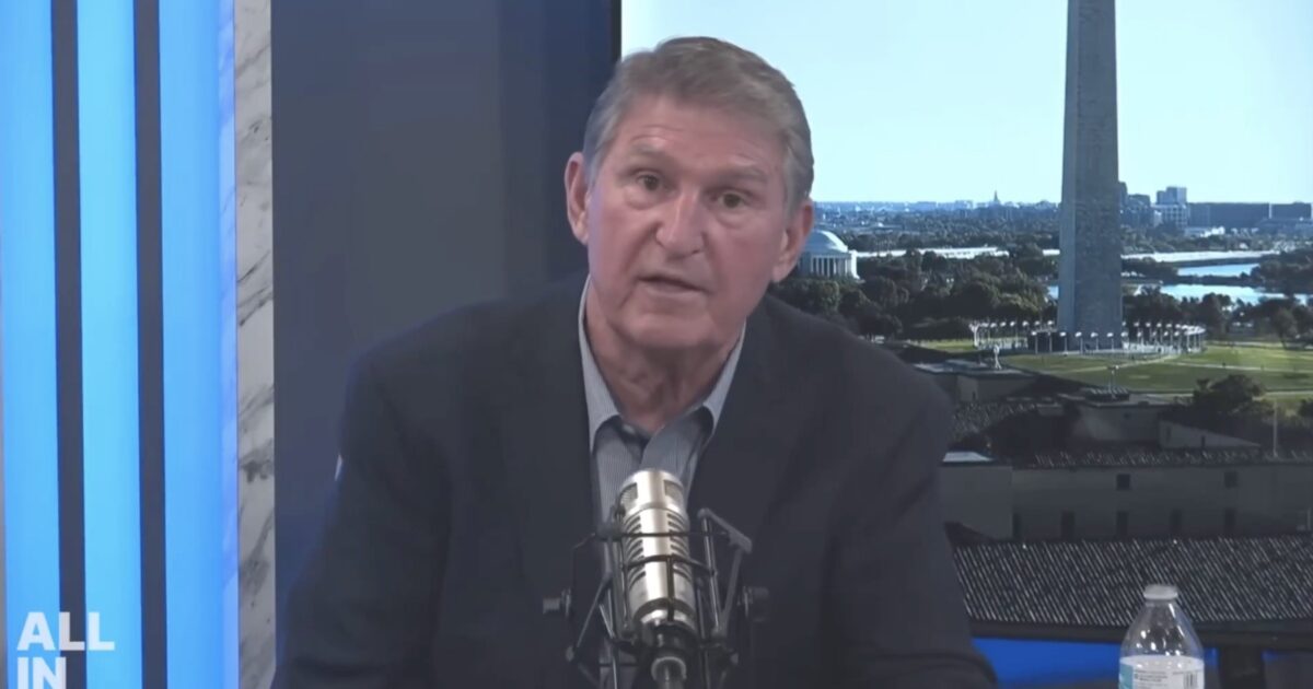 Joe Manchin speaking during a podcast episode with the Washington Monument visible in the background, highlighting political discussions.