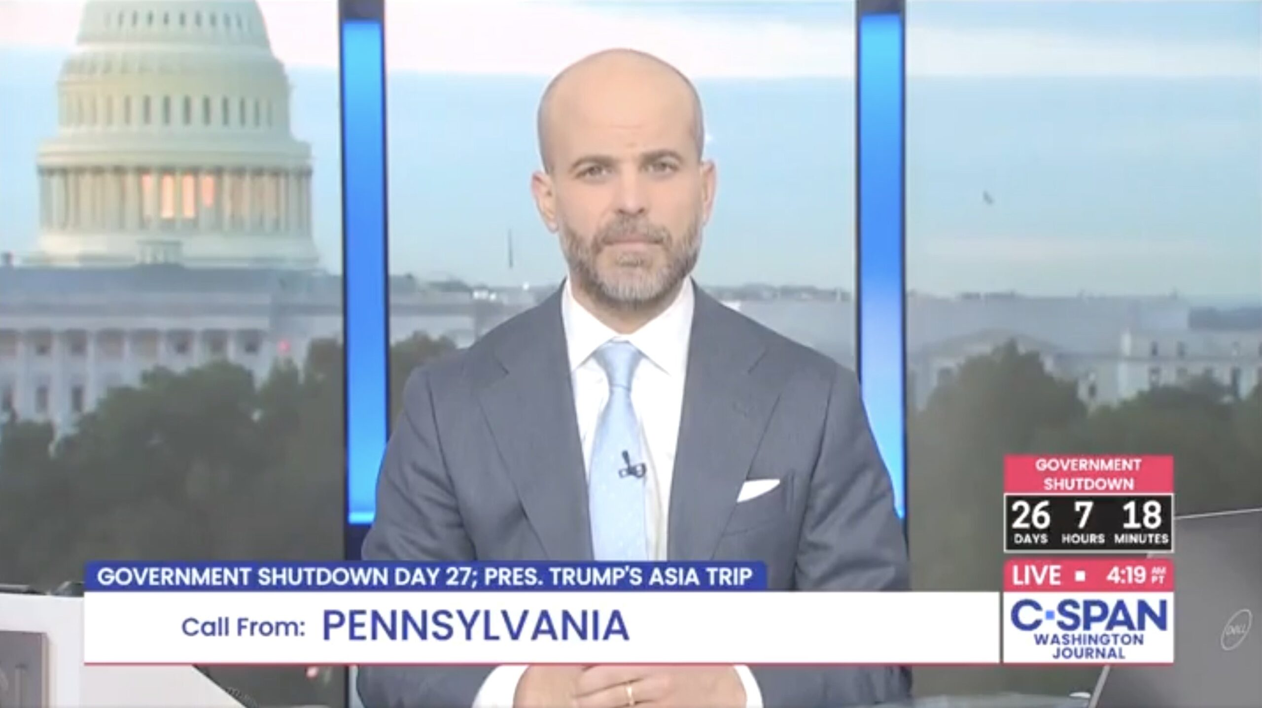 C-SPAN host discusses government shutdown on live broadcast with the U.S. Capitol in the background, highlighting ongoing political issues.