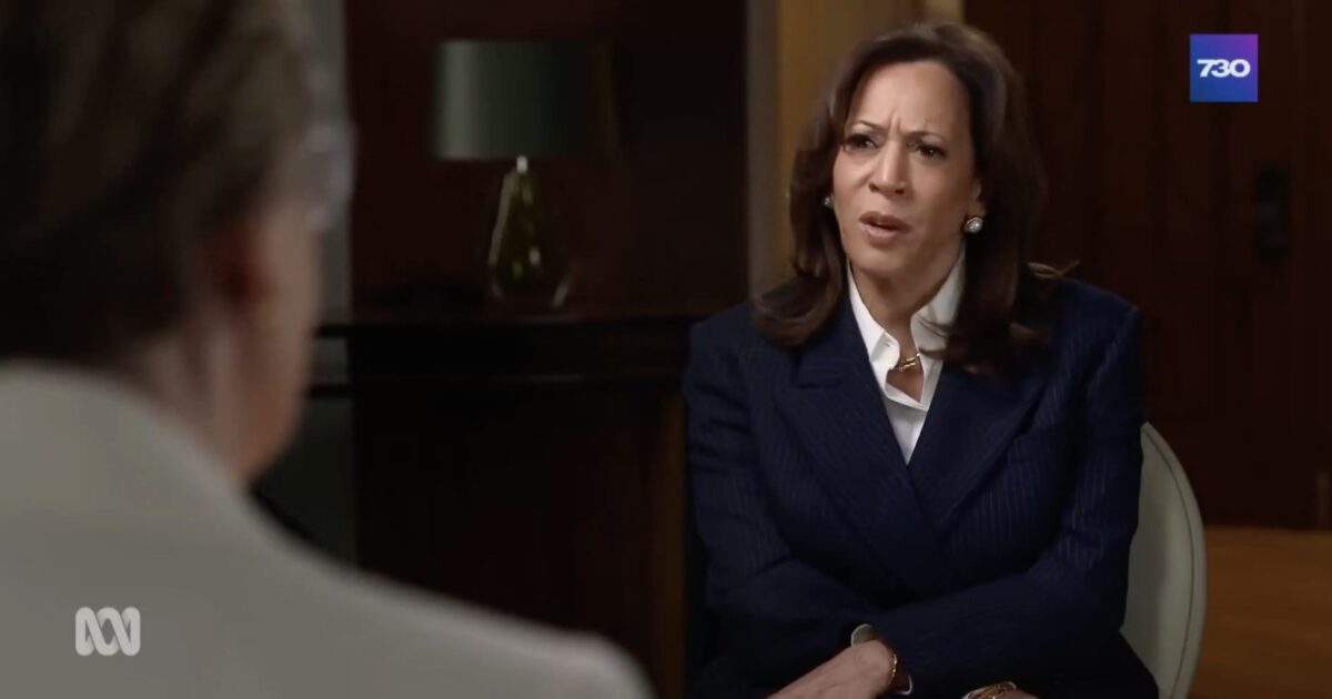 Kamala Harris engaged in an interview, expressing curiosity and concern, while seated in a professional setting with a modern decor background.