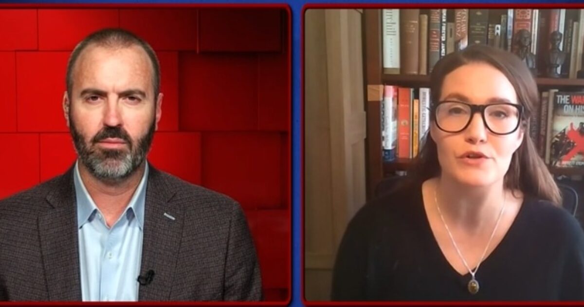 A man and a woman discuss historical topics on a video call, with bookshelves featuring historical texts in the background.