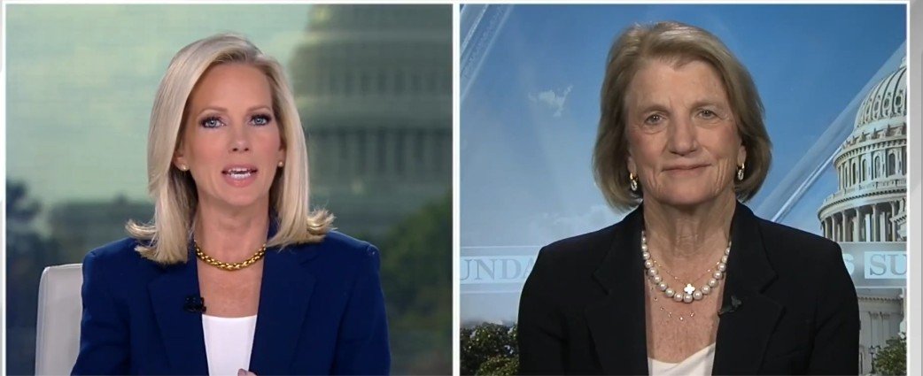 News anchors discussing current events with the U.S. Capitol in the background, featuring two women in professional attire.