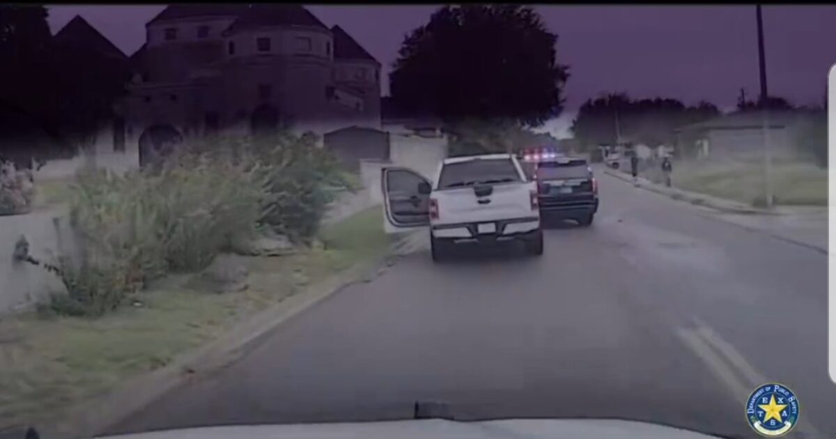 Police vehicles respond to a situation on a residential street, with one truck parked and another approaching with flashing lights.
