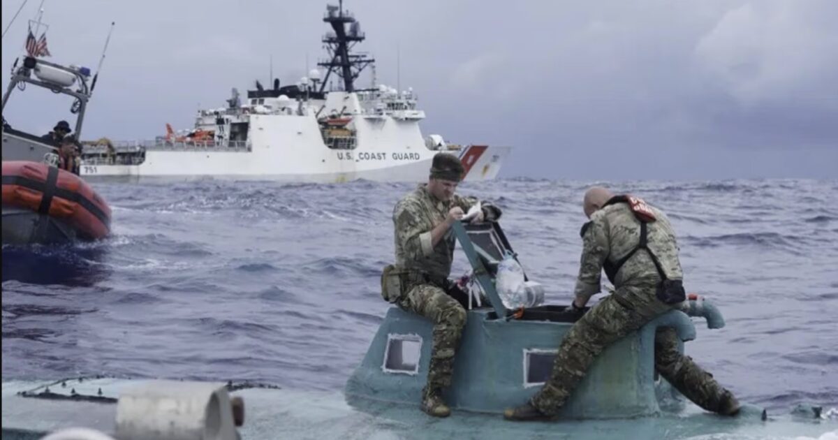 U.S. Coast Guard personnel inspect a small vessel at sea, with a larger Coast Guard ship in the background, showcasing maritime operations and rescue efforts.