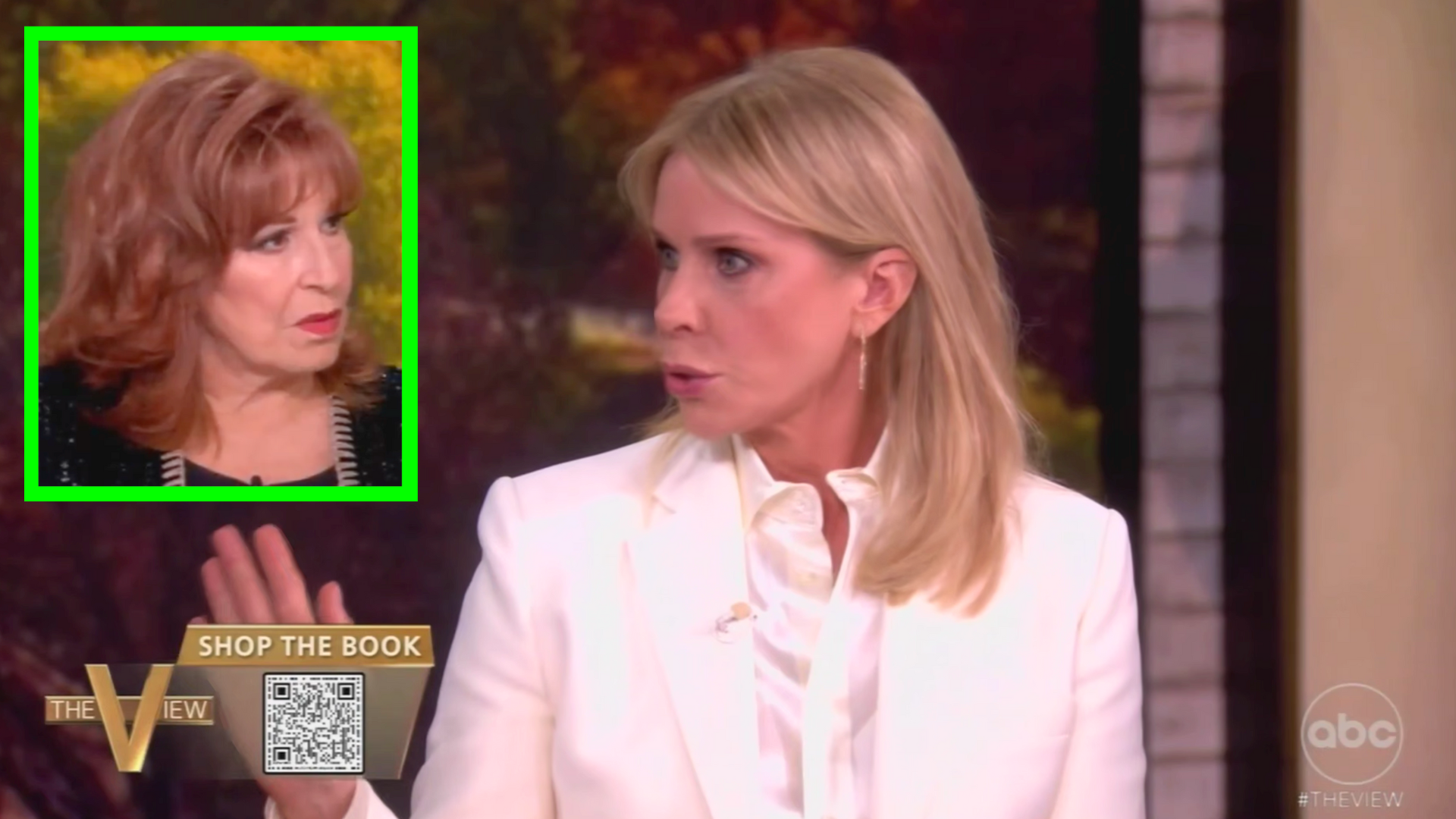 Two women speaking on a talk show, one in a white blazer and the other with red hair, discussing a topic with animated expressions.