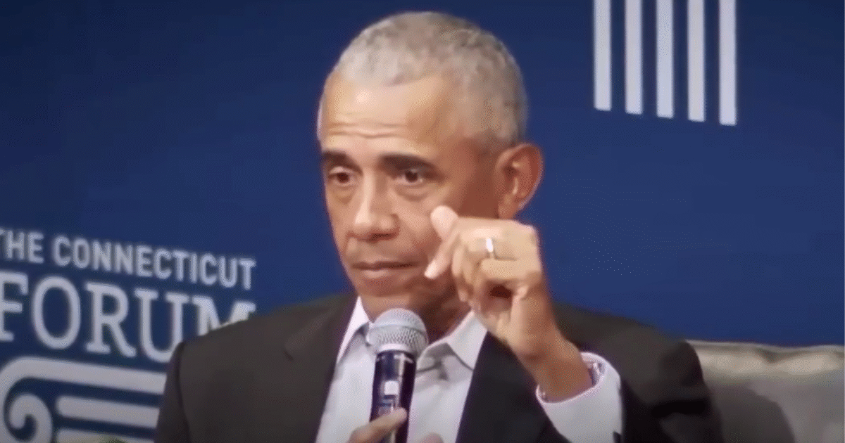 Barack Obama speaking at The Connecticut Forum, discussing key issues while holding a microphone and gesturing with his hand.