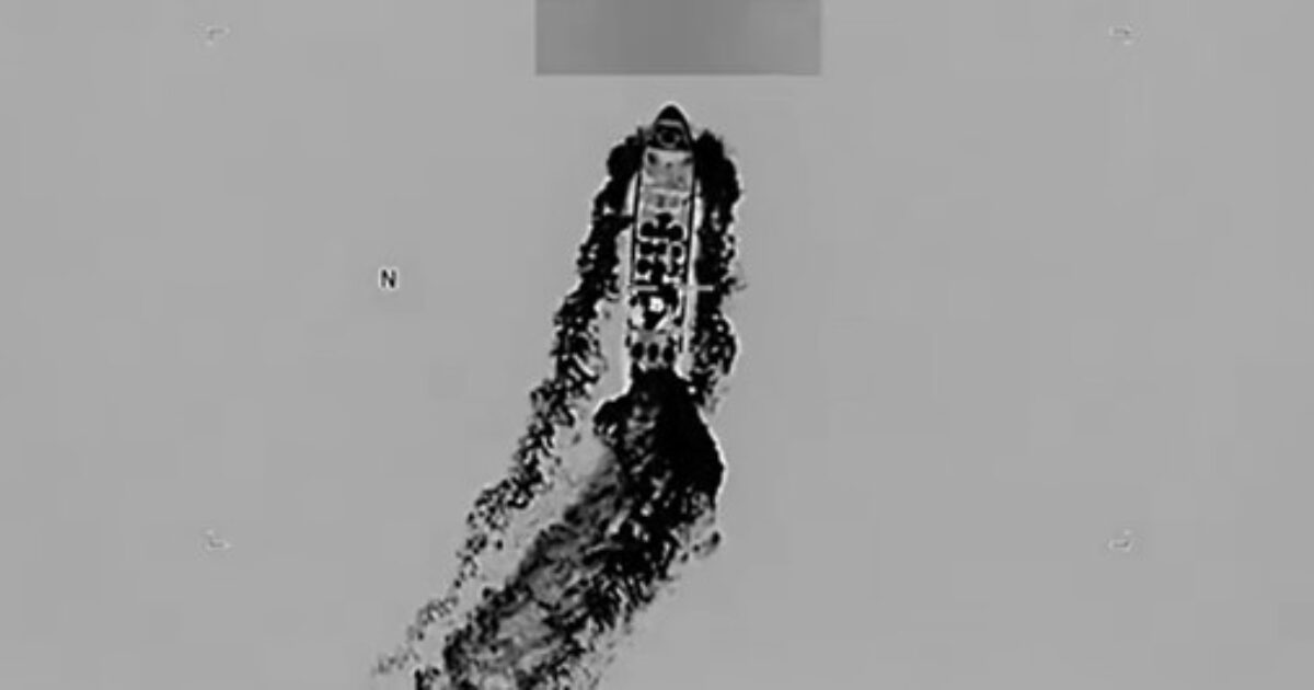 Aerial thermal image of a vessel navigating through water, leaving a distinct wake behind.