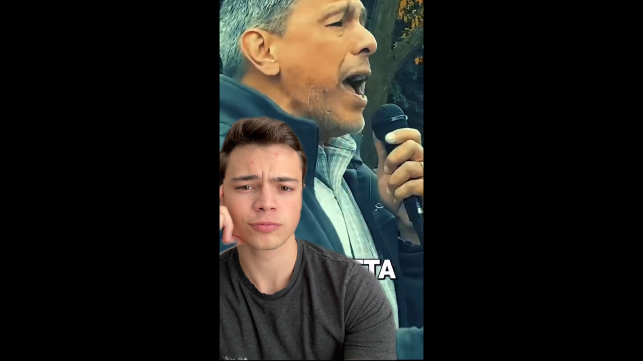 A man singing passionately into a microphone, with another young man looking thoughtfully in the foreground.