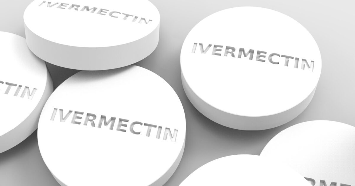White Ivermectin tablets displayed on a neutral background, highlighting their round shape and embossed lettering.