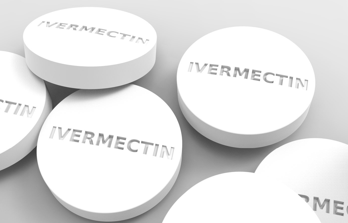 White Ivermectin tablets displayed on a neutral background, highlighting their round shape and embossed lettering.